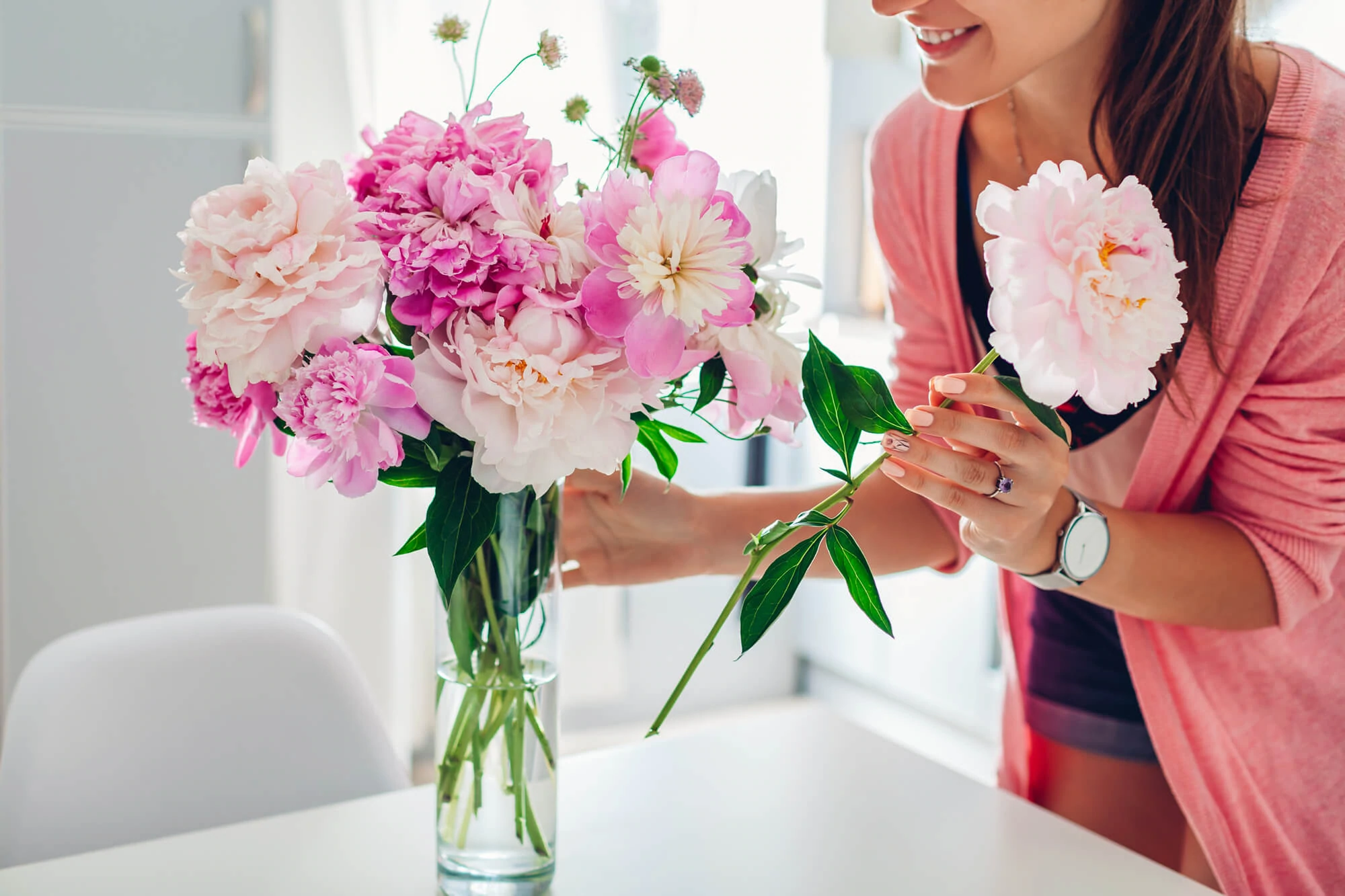 Lady Putting fresh Flowers In A Vase