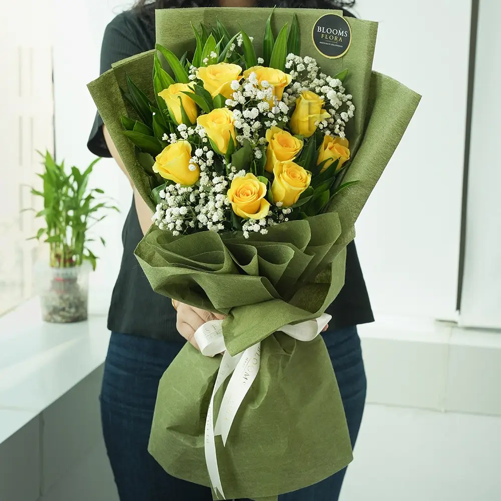 a lady holding a bouquet of 12 yellow roses