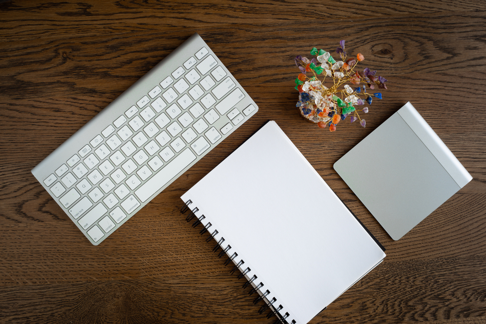 a gemstone tree along with a keyboard, notebook and a trackpad