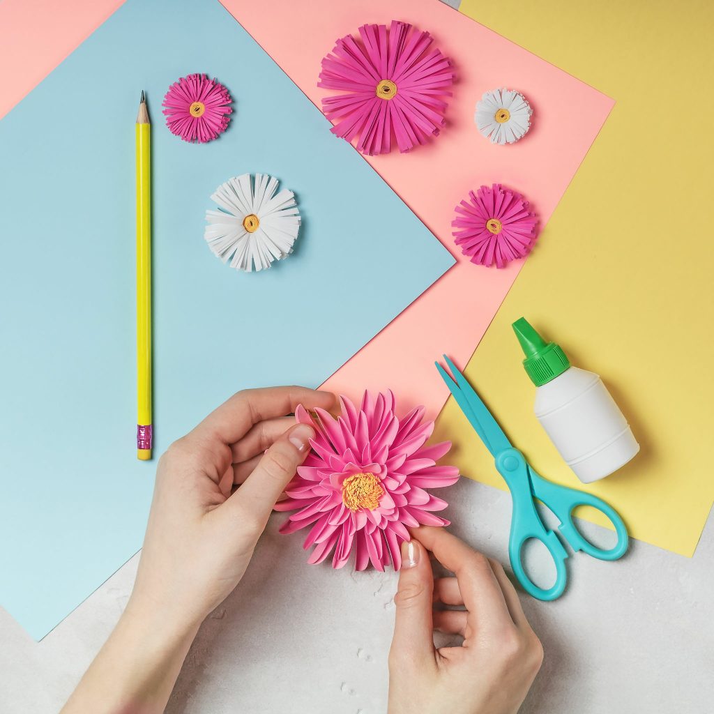 female hands making paper flowers using 