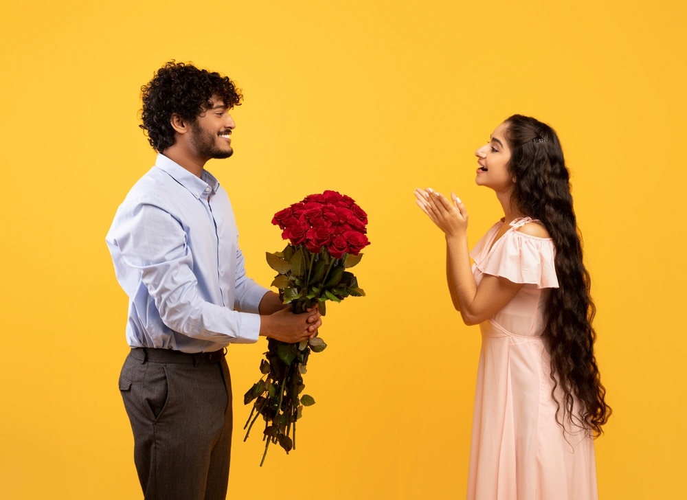 man presenting red roses to his girlfriend 