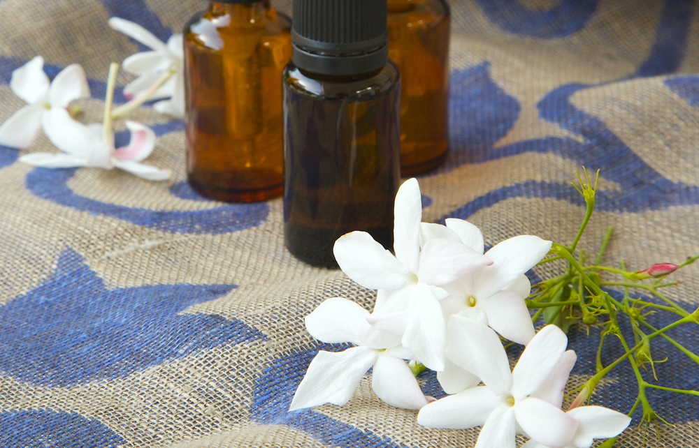 white jasmine flowers with essential oil bottles on a rug