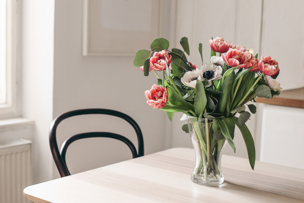 spring flowers in glass vase on wooden table