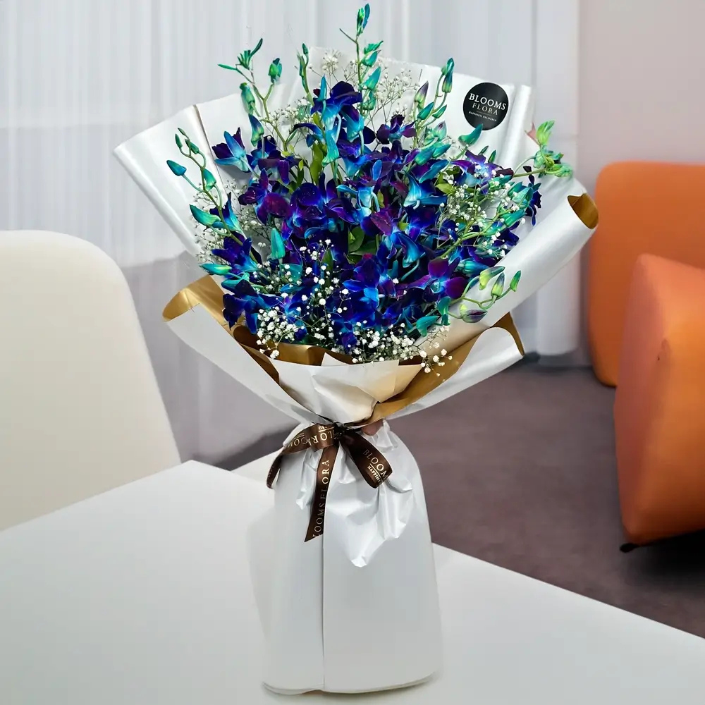 Blue Flowers: What Do They Mean and When Should You Gift Them? 3 Blue flower bouquet with white baby’s breath in elegant white and gold wrapping by BloomsFlora.